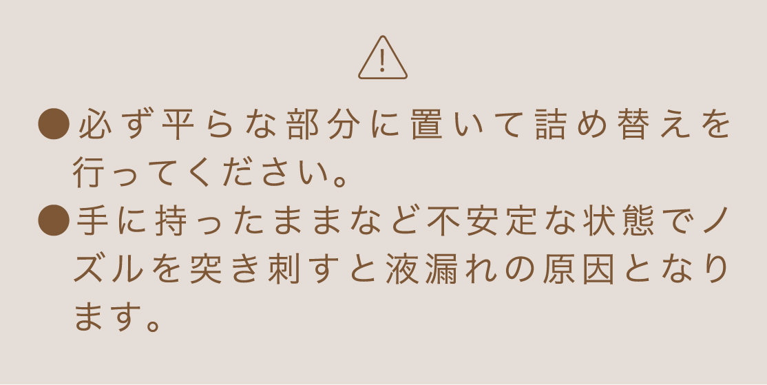 必ず平らな部分に置いて詰め替えを行ってください。手に持ったままなど不安定な状態でノズルを突き刺すと液漏れの原因となります。